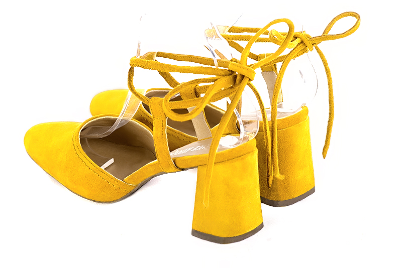 Chaussure femme à brides : Chaussure arrière ouvert avec des brides croisées couleur jaune soleil. Bout rond. Talon haut évasé. Vue arrière - Florence KOOIJMAN