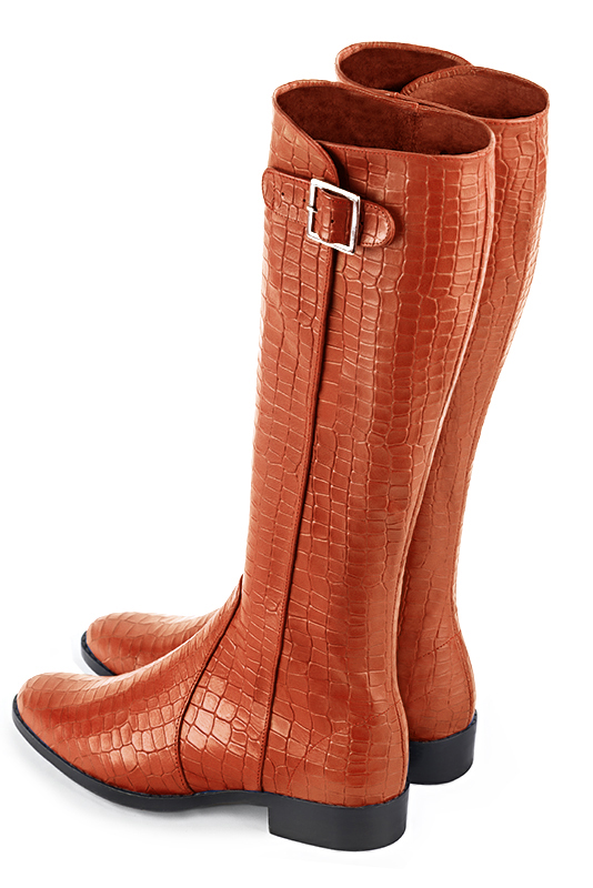 Bottes femme élégantes et raffinées, avec des boucles, réalisées sur mesure, coloris orange safran. Bout rond. Semelle cuir talon plat. Mollets fins ou larges. Personnalisation : Choix des cuirs, des couleurs et des talons. - Florence KOOIJMAN