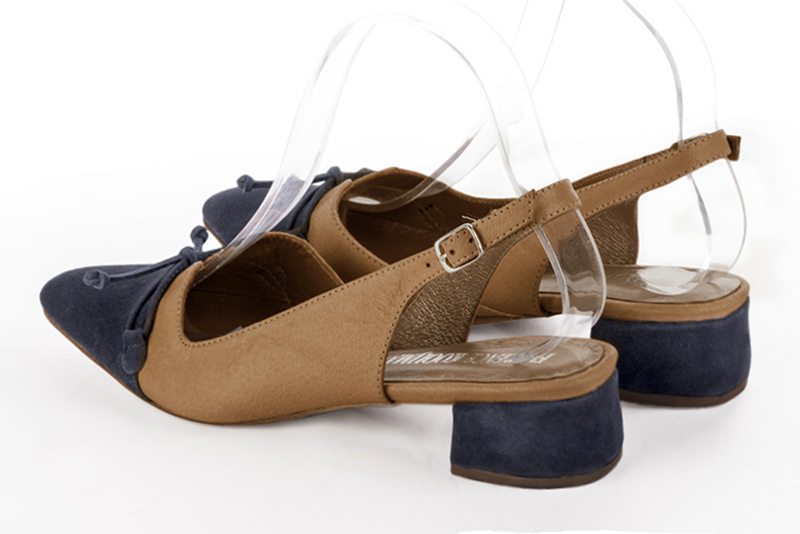 Escarpins habillés, élégants et raffinés, ouverts à l'arrière avec un noeud sur l'avant, coloris bleu marine et beige camel. Bout effilé. Mi-haut. Talon évasé. Cérémonie, soirée, cocktail, évènementiel. Personnalisation : Choix des cuirs, 
                des couleurs et des talons. Petites et grandes pointures. - Florence KOOIJMAN
