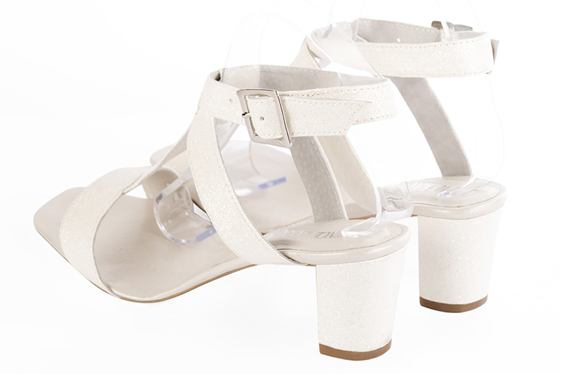 Sandales habillées complétement ouvertes, élégantes et raffinées, avec des brides croisées, coloris blanc cassé. Bout carré. Mi-haut à haut. Talon bottier. Cérémonie, soirée, cocktail, évènementiel. Personnalisation : Choix des cuirs, 
                des couleurs et des talons. Petites et grandes pointures. - Florence KOOIJMAN