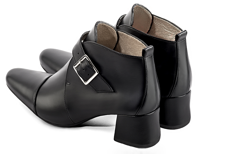 Bottines élégantes et raffinées avec des boucles à l'avant, coloris noir satiné. Bout rond. Mi-haut. Talon évasé. Personnalisation : Choix des cuirs, des couleurs et des talons. Cou-de-pied sur mesure. - Florence KOOIJMAN