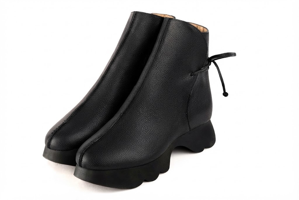 Bottines à laçage arrière pour femme en cuir noir avec bout rond et semelle épaisse et sculpturale en gomme - Vue avant