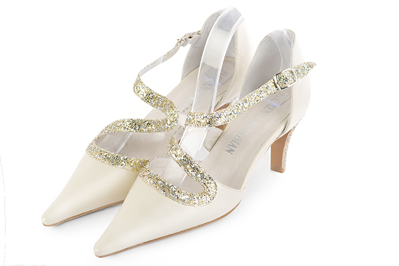 Chaussures habillées, élégantes et raffinées, ouvertes sur les côtés, avec une bride en forme de serpent, coloris blanc cassé et or doré. Bout pointu. Mi-haut à haut. Talon fin. Cérémonie, soirée, cocktail, évènementiel. Personnalisation : Choix des cuirs, 
                des couleurs et des talons. Petites et grandes pointures. - Florence KOOIJMAN