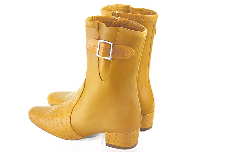 Boots femme : Boots avec des boucles sur le côté couleur jaune ocre. Bout rond. Petit talon bottier. Vue arrière - Florence KOOIJMAN