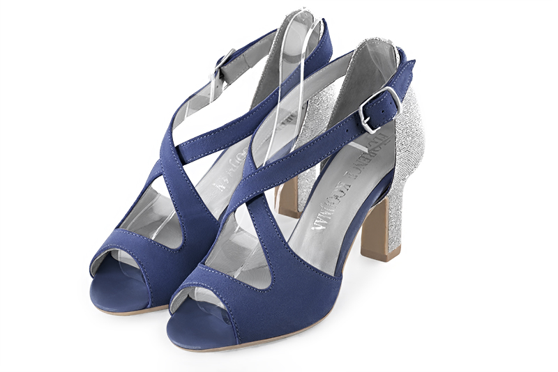Chaussure femme ouverte : Sandale avec l'arrière fermé et des brides croisées sur le cou-de-pied couleur bleu indigo et argent platine. Talon haut. Talon trotteur. Bout rond - Florence KOOIJMAN