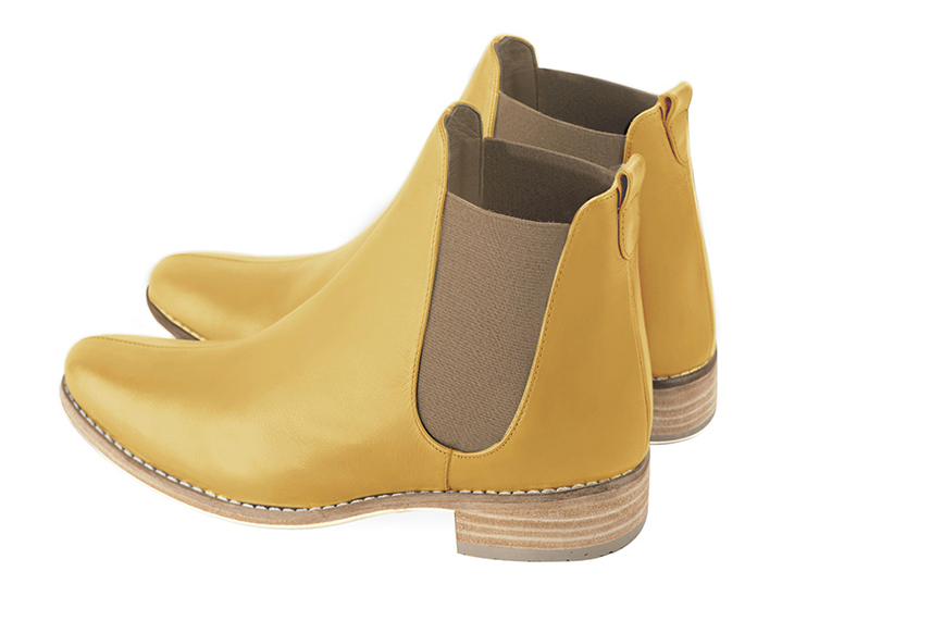 Boots femme : Boots élastiques sur les côtés couleur jaune ocre et marron taupe. Bout rond. Semelle cuir talon plat. Vue arrière - Florence KOOIJMAN