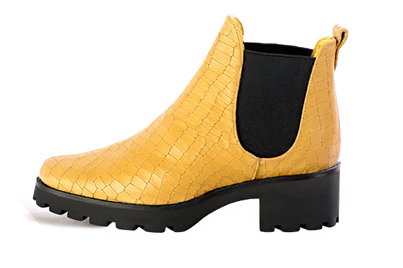 Boots femme : Boots élastiques sur les côtés couleur jaune ocre et noir mat. Bout rond. Semelle gomme petit talon. Vue de profil - Florence KOOIJMAN